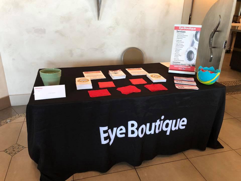 Table covered in black cloth with eyewear coupons and other information on printed cards